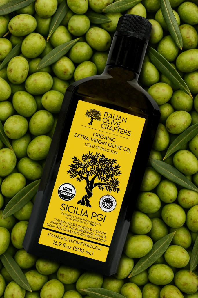 Decorative Image that shows the Bottle of Olive oil placed on top of some olives.